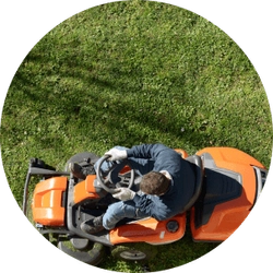 An orange lawn mower cutting grass.